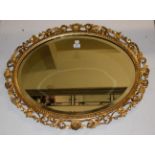 An oval bevel edged wall mirror in gilt wood Florentine frame, 83cm by 65cm