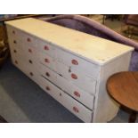 A Victorian white painted chest fitted with an arrangement of twelve drawers, 214cm by 55cm by 91cm