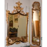 A reproduction gilt and black painted mirror, the shaped bevelled plate within leaf scroll frame