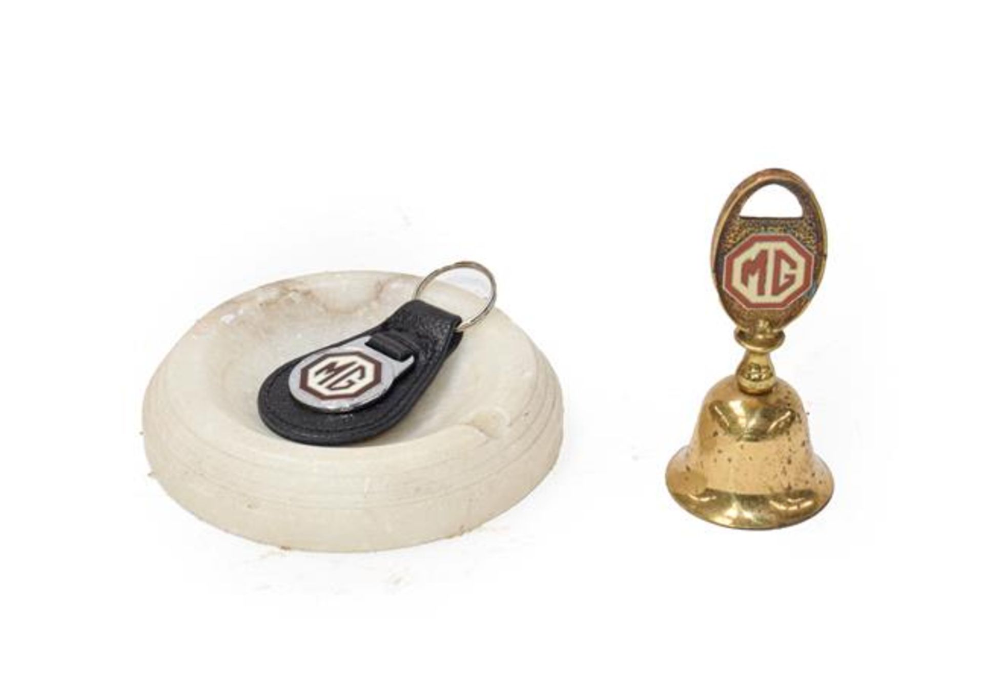 An MG Circular Marble Showroom Ashtray; A Brass Novelty Tea Bell, with MG emblem; and An MG
