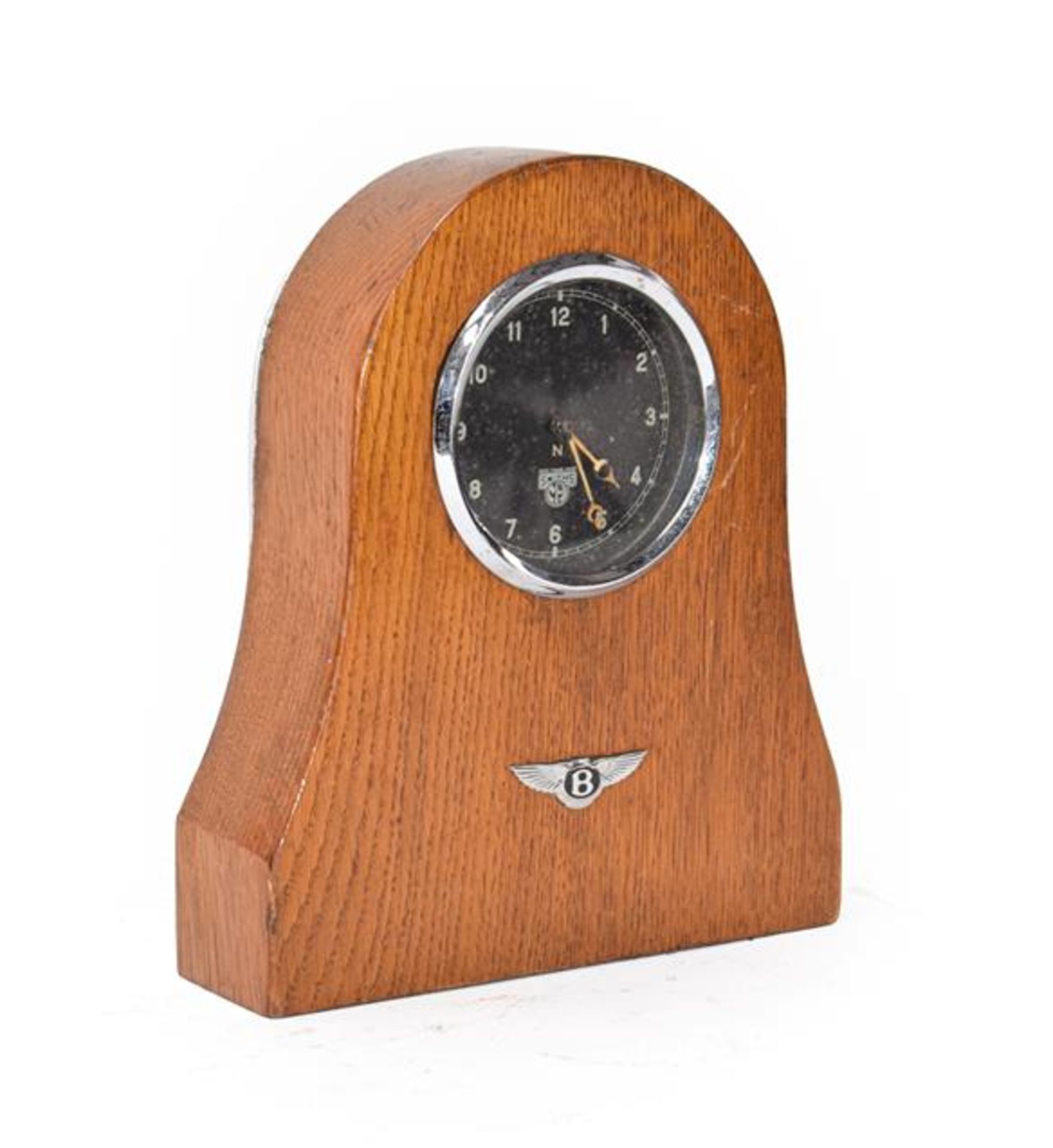 A 1930's Smith's Car Clock, mounted in an oak case with Bentley winged badge emblem, 20cm high