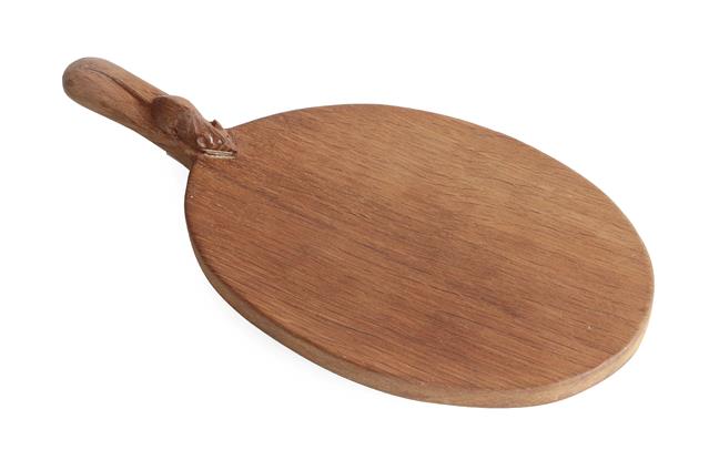 Workshop of Robert Mouseman Thompson (Kilburn): An English Oak Cheese Board, of standard form,