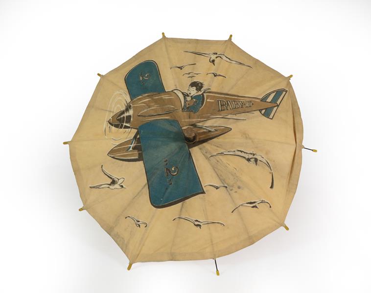 A Second World War Child's Advertising Umbrella, the white cotton canopy printed with a boy flying a