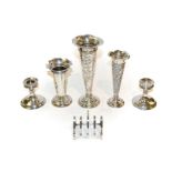 A collection of assorted silver including three vases, a toast rack and a pair of candlesticks,