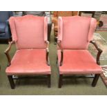 A pair of Georgian style mahogany framed wing back armchairs