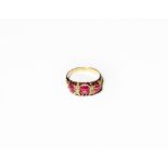 A synthetic ruby and diamond ring, three graduated oval cut synthetic rubies alternate with pairs of
