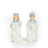 A pair of Ceramic figures, modelled as a man and female, each with white bodies heightened with