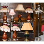 A set of four red glazed baluster form pottery table lamps with silk shades, together with three