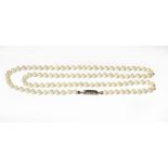 A cultured pearl necklace knotted to a sapphire clasp stamped '750', length 81.5cm . Gross weight