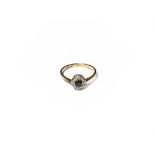 An 18 carat gold sapphire and diamond cluster ring, the oval cut sapphire within a border of eight-