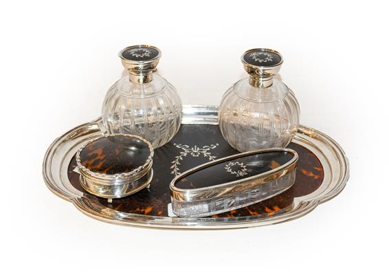 A silver and tortoiseshell dressing table set