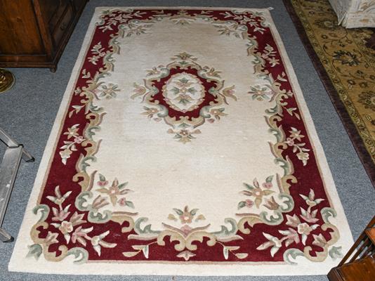 An Indian rug, the ivory field with floral medallion framed by borders 24cm by 152cm