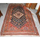 A Kashgai rug, the indigo field with ivory serrated medallion framed by spandrels and narrow