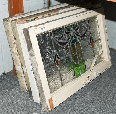 A set of four leaded and coloured glass windows in white painted frames, circa 1900/1910, each