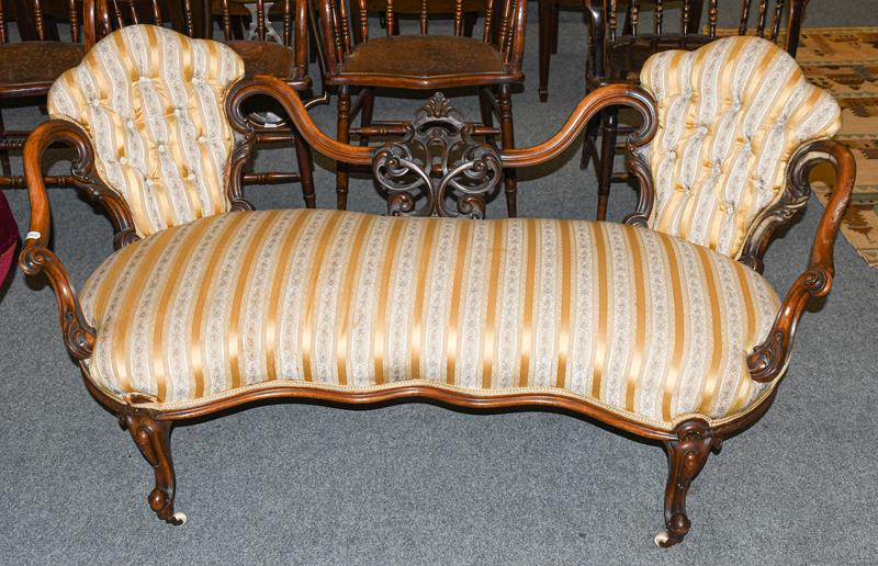 A Victorian carved walnut framed open sofa upholstered in striped fabric, 155cm long