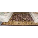 Large Indian carpet, the aubergine field with an all over design of large flower heads and vases