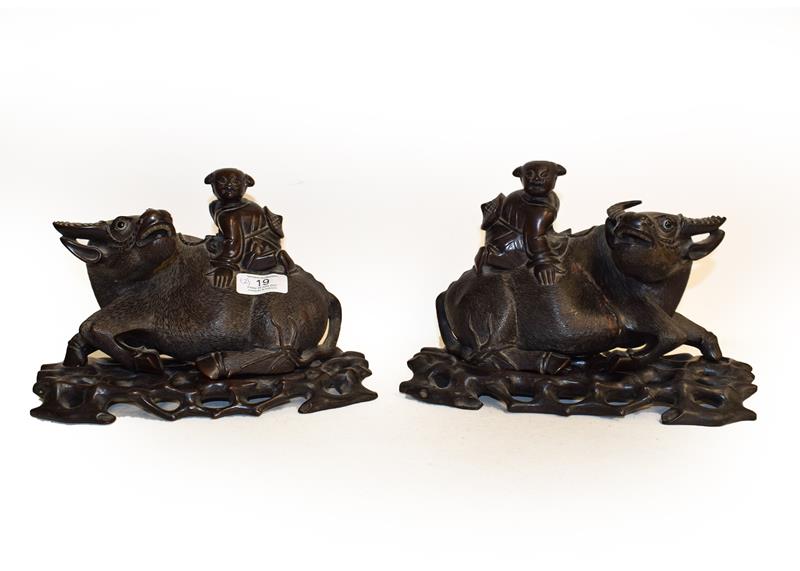 A pair of wooden carved models of water buffalo, 24cm wide