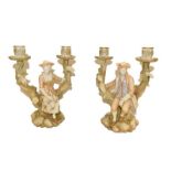 A pair of Royal Worcester candelabra, modelled with figures seated on a tree stump with two