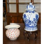 A blue and white jar and cover on wooden stand, and an early 20th century flared shaped famille rose