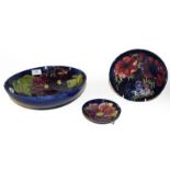 Three Moorcroft bowls, Cobalt blue ground, Clematis and Anemone pattern, the largest 26.5cm