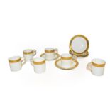 A set of six Royal Worcester coffee cans and saucers decorated with gilt and scrolling, date code