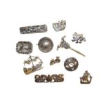 Ten silver brooches of varying designs, and a pair of earrings stamped 'SILVER'. Gross weight 83.0