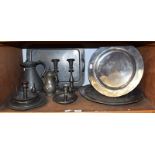 A quantity of pewter comprising chargers, jug, candlesticks, tray, etc (one shelf). Cone shaped