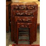 A 20th century Chinese hardwood nest of four tables carved with leaves and berries, 47cm by 34cm