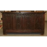 An 18th century panelled oak coffer, with hinged lid and carved frieze, 128cm by 58cm by 70cm