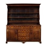 A George III Oak Enclosed Dresser and Rack, late 18th century, the upper section with bold cornice