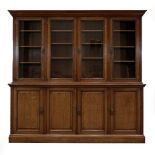 A Victorian Oak Bookcase, late 19th century, the bold cornice above four glazed doors with reeded