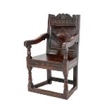 A 17th Century Joined Oak English Armchair, the carved top rail above a lozenge carved back support,