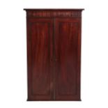 A Mahogany Wall Cabinet, 2nd quarter 19th century, with two panel doors enclosing an arrangement