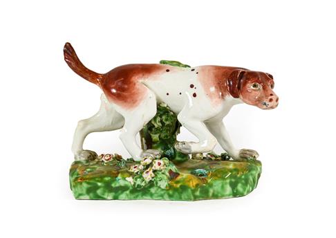 A Derby Porcelain Figure of a Hound, circa 1790, on a mound base, 16.5cm long. Restoration to