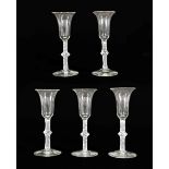 A Set of Five Wine Glasses, circa 1750, the bell shaped bowls on knopped opaque twist stems, 16.
