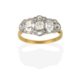 A Diamond Cluster Ring, an old cut diamond flanked by oval cut diamonds, within a border of old