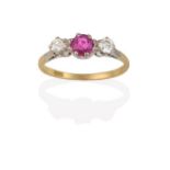 A Pink Sapphire and Diamond Three Stone Ring, the central round cut pink sapphire flanked by round