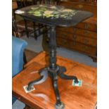 An early 19th century carved ebony centre pedestal snap-top table with paper mache top, painted with