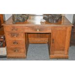 An oak pedestal desk with a set of four drawers and a cupboard. 137cm by 76cm by 79cm