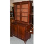 ~A Victorian mahogany bookcase raised on a two-door cupboard base, on turned feet, 101cm by 52cm