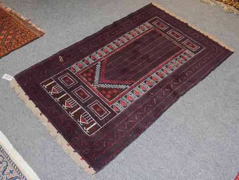 An Afghan Baluch rug the field with columns of barber poles beneath the Mihrab enclosed by triple