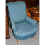 A Victorian blue upholstered armchair moving on castors