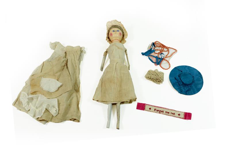 A Late 18th Century Queen Anne Type Doll, with a carved wooden head, blonde wig, wide carved eyes