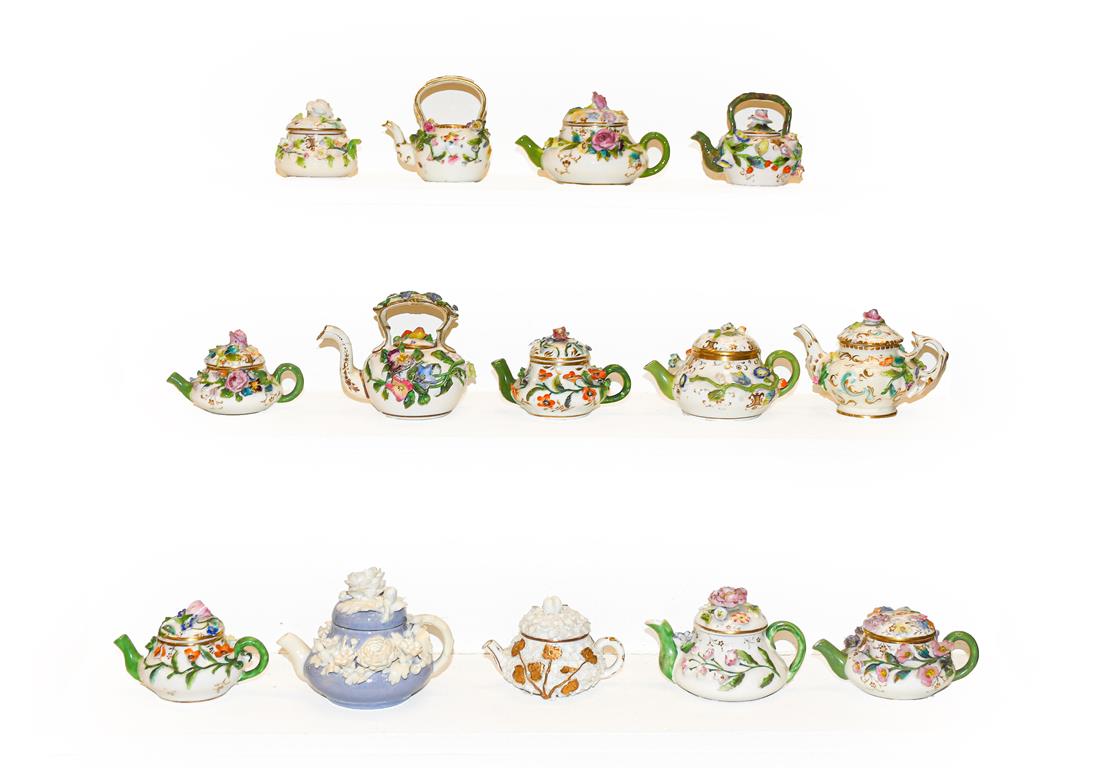 A quantity of mainly 19th century English porcelain miniature teapots, all decorated with applied