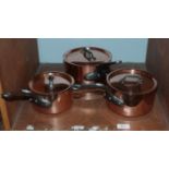 A set of three graduated covered saucepans, copper on stainless steel (3)