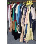 An assortment of clothing, to include: ladies day wear, dresses, wedding dress, jackets, coats,