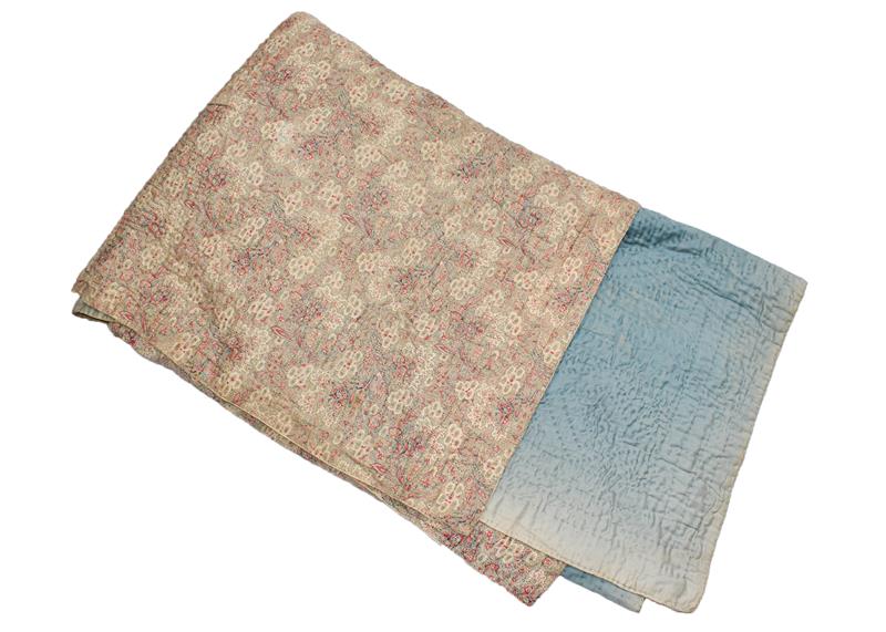 A late 19th century whole cloth quilt, mounted with a printed floral cotton in pinks, grey and