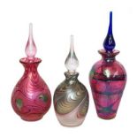 Okra glass comprising three iridescent scent bottles, one signed to the base D. Bannas, tallest 18.