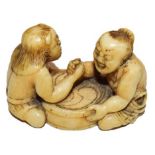 A Japanese Meiji period ivory netsuke in the form of arm wrestlers, signed to base