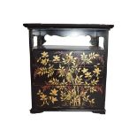 An early 20th century Japanese lacquered table cabinet, decorated in gilt and red enamel with